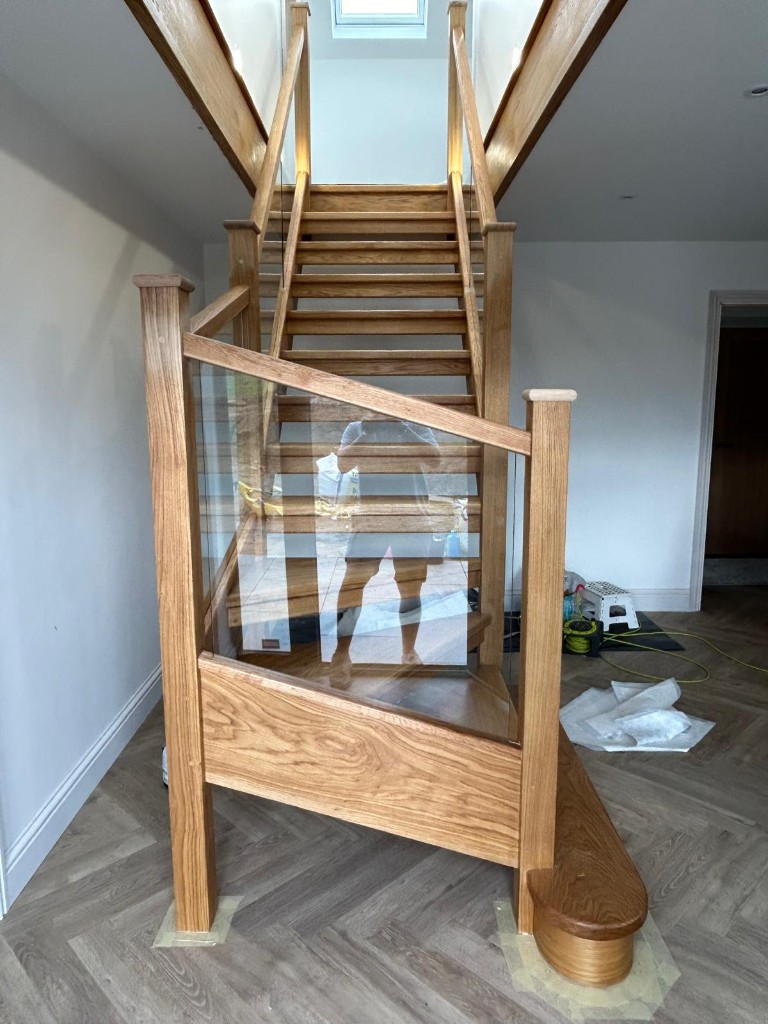 Front view of a custom solid oak open plan staircase with glass balustrading in Cliffe Woods, Kent