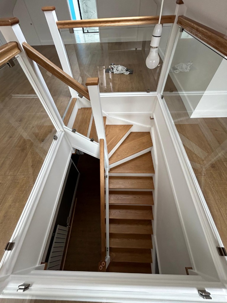 Looking down a custom oak and pine staircase with glass balustrading in Cuxton, Kent