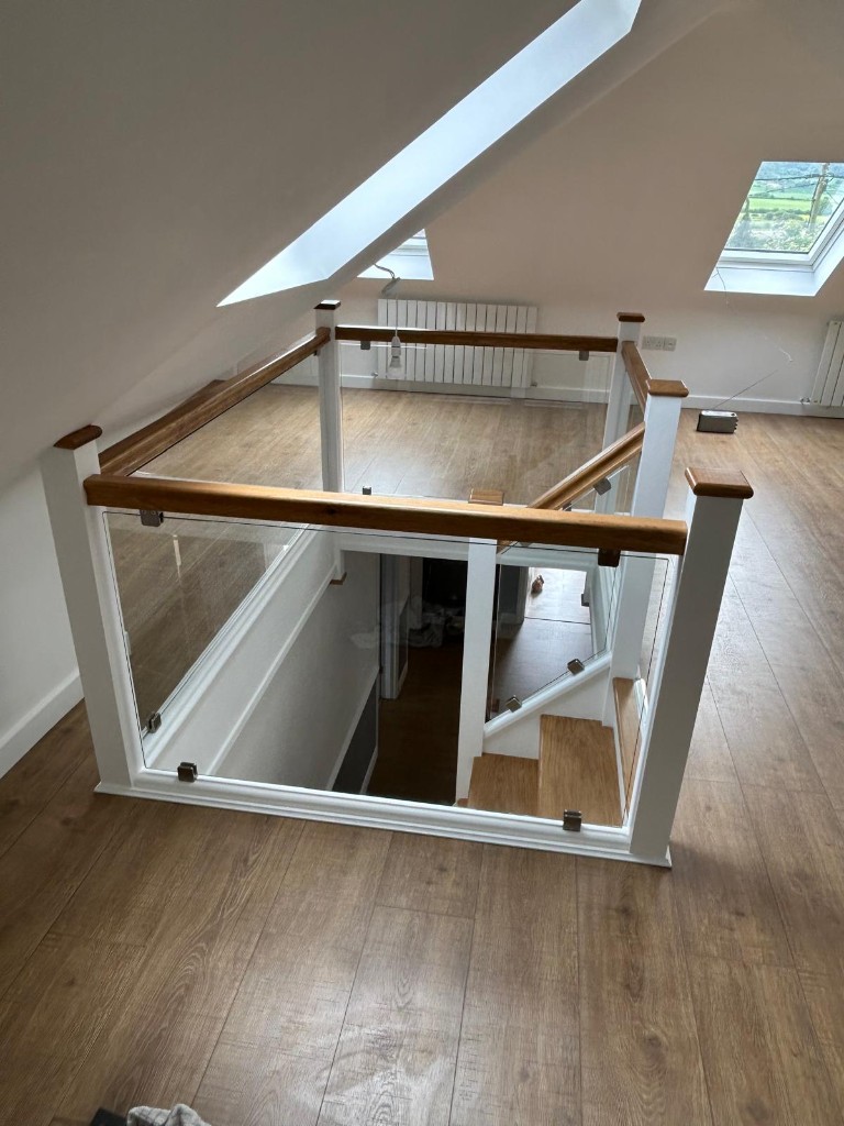 Upper landing of a custom oak and pine staircase with oak and glass balustrading in Cuxton, Kent